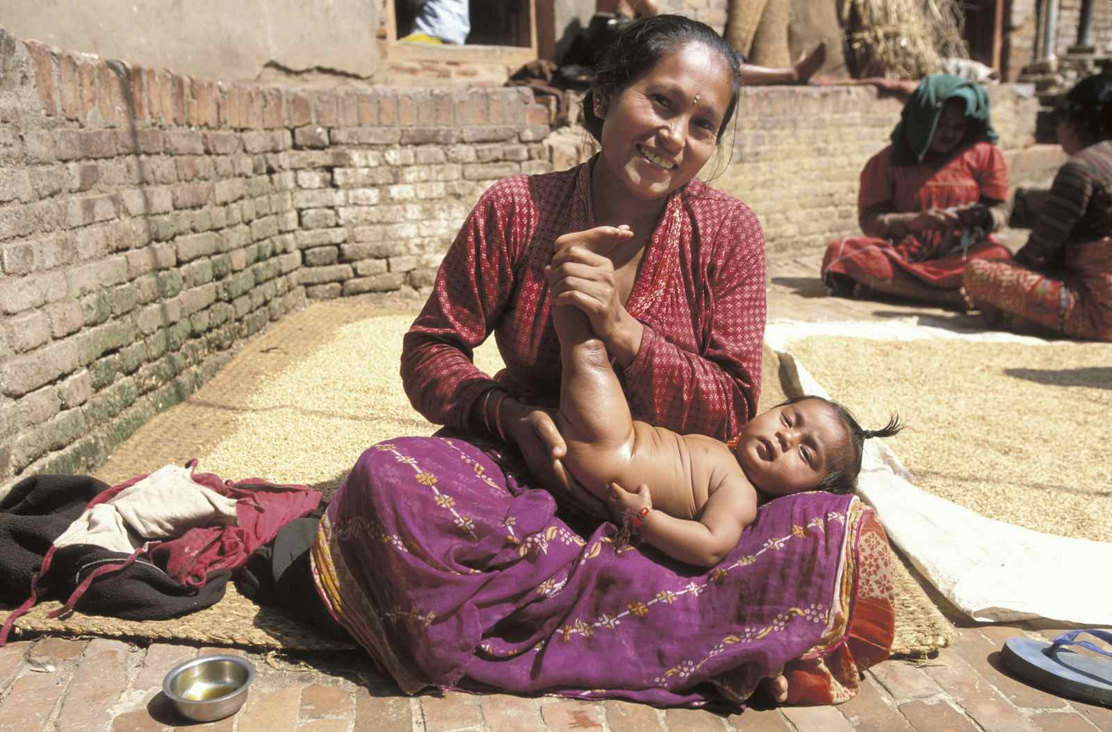 Woman massaging her baby with oil, picture taken in Nepal (BSIP/Universal Images Group via Getty Images)