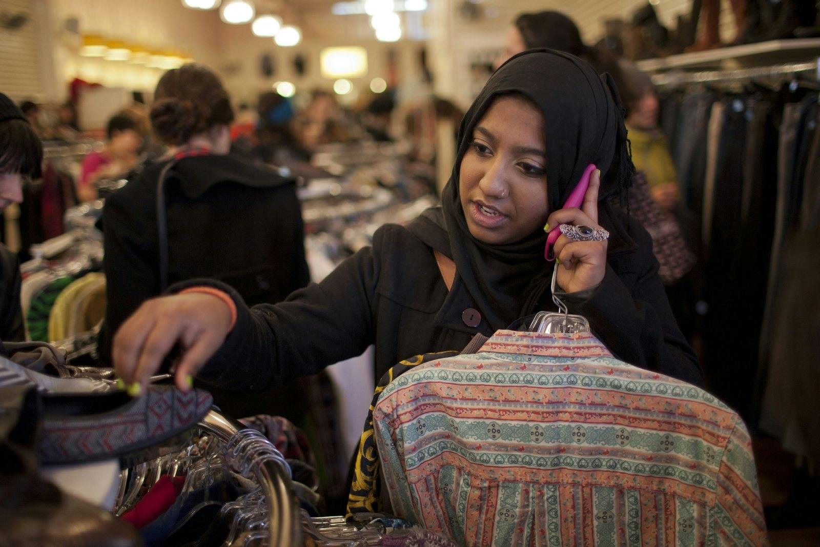 Sharmin Hossain, a 20 year old Bangladeshi-American, speaks on her cell phone while shopping January 2, 2012 in a thrift store in Brooklyn, New York (Robert Nickelsberg/Getty Images)
